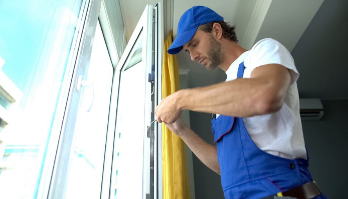Handyman using screwdriver to fix window, repair and installation services